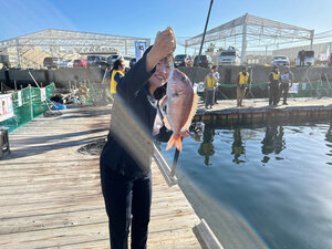 桟橋の上で魚を持った女性